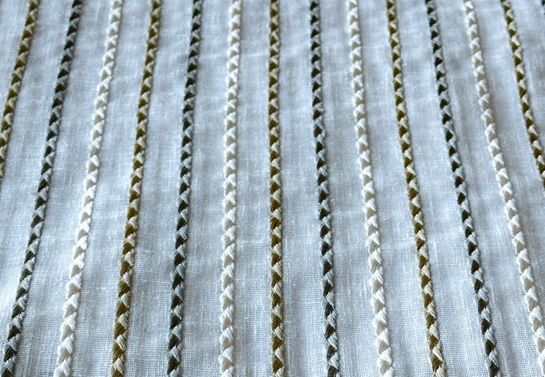 May include: White fabric with vertical stripes of white, brown, and gray thread.