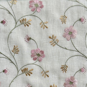May include: A white fabric with embroidered pink flowers and green leaves. The fabric has a subtle linen texture.