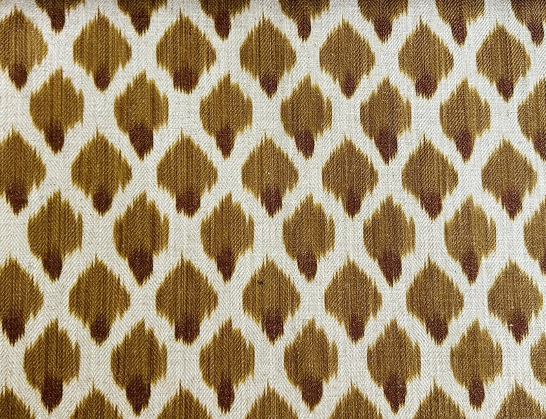 May include: Brown and white fabric with a repeating pattern of small, diamond-shaped motifs. The fabric has a subtle texture.