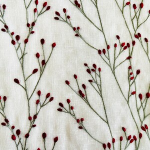 May include: Embroidered fabric with a white background and a repeating pattern of green stems with small red berries.