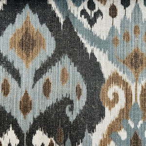 Puede incluir: Primer plano de una tela con un patr&oacute;n ikat azul, marr&oacute;n y blanco.