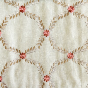 Puede incluir: Tela beige con un patr&oacute;n repetido de hojas bordadas marrones y peque&ntilde;as flores rojas.