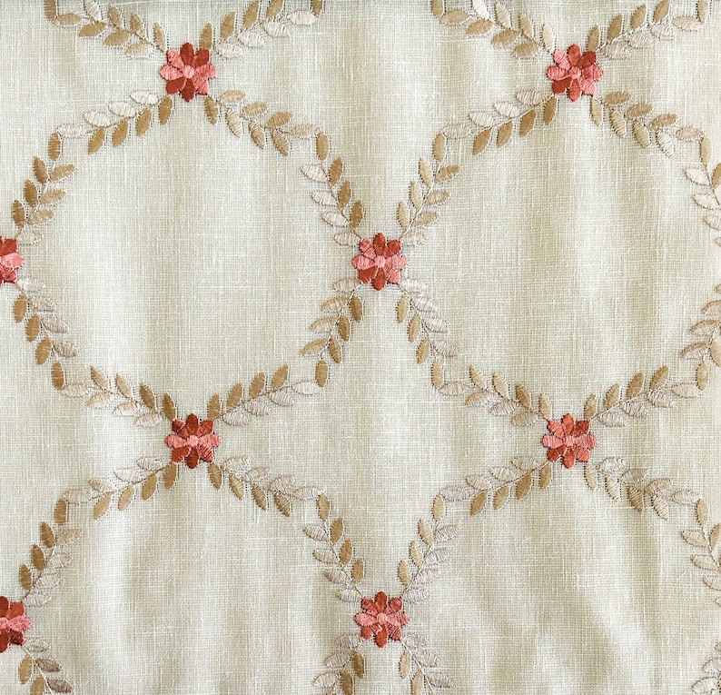 Puede incluir: Tela beige con un patr&oacute;n repetido de hojas bordadas marrones y peque&ntilde;as flores rojas.