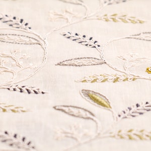 May include: White fabric with embroidered floral designs in shades of gray, white, and gold.