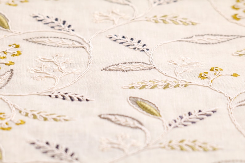 May include: White fabric with embroidered floral designs in shades of gray, white, and gold.