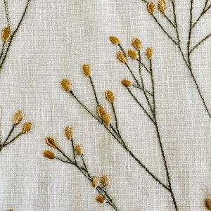 May include: White fabric with a delicate embroidered design of gold sprigs and leaves.