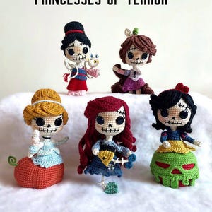 Könnte beinhalten: Sechs handgefertigte Häkelpuppen, jede mit einem Skelettgesicht und Prinzessinnenkleidung. Die Puppen haben verschiedene Haarfarben und Outfits, darunter Rot, Blau und Gelb. Der Text "PRINCESSES OF TERROR" befindet sich oben im Bild.