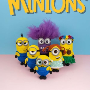Peut inclure: Six figurines de Minions crochetés, chacun avec un design unique. Les Minions sont jaunes avec des salopettes bleues, et certains ont des caractéristiques distinctives telles que des cheveux violets, une jupe en herbe et des bandeaux floraux. Le mot "MINIONS" est affiché en jaune.
