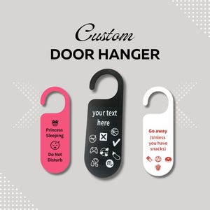Pode incluir: Cabides de porta personalizados em rosa, preto e branco. O cabide rosa diz "Princesa dormindo, Não incomodar". O cabide preto tem espaço para texto e ícones personalizados. O cabide branco diz "Vá embora (A menos que tenha lanches)."