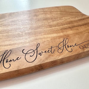 May include: A wooden serving board with the text "Home Sweet Home" and the number "04252" engraved in a cursive font.