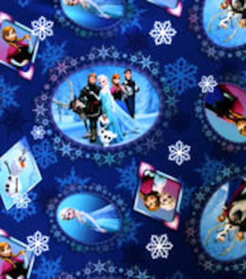 Puede incluir: Tela azul con personajes de la pel&iacute;cula "Frozen." El dise&ntilde;o incluye a Elsa, Anna, Kristoff, Olaf y Sven, sobre un fondo de copos de nieve y marcos ovalados. Adecuada para diversos proyectos de manualidades.