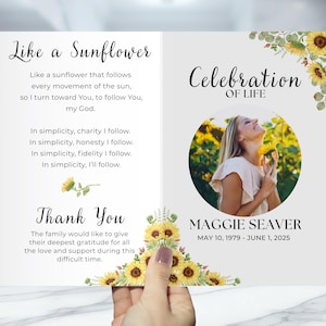 May include: A memorial card with the text "Like a Sunflower" and "Celebration of Life." The card features a photo of a woman and sunflower illustrations. The card includes the dates May 10, 1979 - June 1, 2025.
