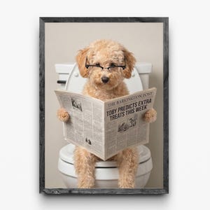 May include: A framed print features a light brown poodle wearing glasses and sitting on a toilet, reading a newspaper. The newspaper headline reads, "TOBY PREDICTS EXTRA TREATS THIS WEEK." The frame is dark gray.