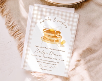 May include: Baby shower invitation with a stack of pancakes and a pacifier illustration. The invitation features the text "pancakes & pacifiers" and details for Evelyn Monroe's baby shower, including date, time, and location.