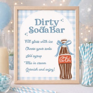 May include: A framed sign with the text "Dirty Soda Bar" in blue script. The sign includes instructions and a cola bottle illustration. The background is a light blue gingham pattern, with blue and white striped straws.