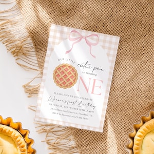May include: A birthday invitation with a pie graphic and the text "Our little cutie pie is turning ONE." The invitation is light pink and beige, with the text "Winnie's first Birthday" and event details.