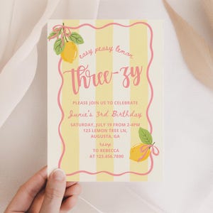 K&ouml;nnte beinhalten: Eine Geburtstagseinladung mit Zitronen-Thema. Die Einladung hat einen cremefarbenen Hintergrund mit gelben Streifen und einem rosa wellenf&ouml;rmigen Rand. Der Text "Three-zy" ist in rosa Schrift geschrieben. Die Einladung enth&auml;lt Details f&uuml;r eine dritte Geburtstagsfeier.