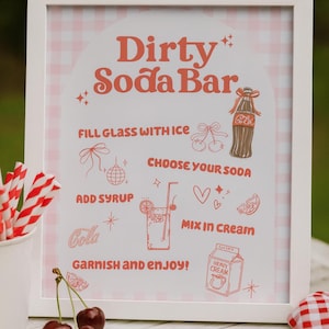 May include: A framed sign with the text "Dirty Soda Bar" in a retro font. The sign includes instructions and illustrations for making a soda, with a pink and white gingham background. Red and white striped straws and cherries are in the foreground.