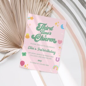 May include: A pink birthday invitation with the text "Third Time's a Charm" in green and white. The invitation includes the details for Ellie's 3rd birthday, with decorative stars, a rainbow, and a horseshoe.