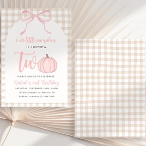 May include: A two-sided invitation with a pink pumpkin graphic and the text "Our little pumpkin is turning two." The invitation features a pink bow and a gingham pattern background. The text includes the date, time, and location of the birthday party.