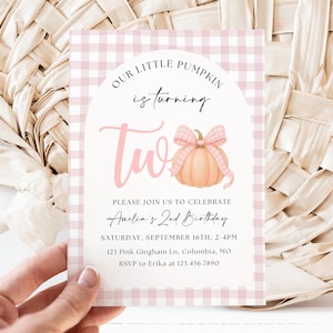 May include: A pink and white gingham-patterned invitation card with the text "Our Little Pumpkin is turning Two." The card features a pumpkin illustration with a bow. The invitation is for Amelia's 2nd birthday.