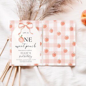 May include: A two-page invitation with a peach theme. The left page has a peach and bow illustration with the text "SHE IS ONE sweet peach." The right page has a pink and white gingham pattern with peach illustrations. The invitation is for Ellie's first birthday.