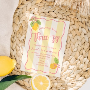 K&ouml;nnte beinhalten: Eine Geburtstagseinladung mit Zitronen-Thema. Die Einladung hat gelbe und wei&szlig;e Streifen mit den Worten "Three-zy" in Rosa. Die Einladung enth&auml;lt auch den Text "easy peasy lemon" und "Junie's 3rd Birthday".
