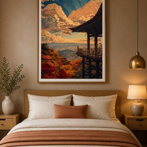 May include: A framed print of a Japanese temple overlooking a valley, with vibrant autumn foliage. The artwork features a detailed depiction of the temple's architecture, set against a backdrop of a sunset sky with fluffy clouds. The frame is a light brown color.