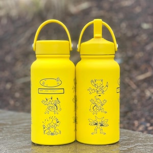 May include: Two yellow water bottles featuring black cartoon character illustrations. Each bottle has a handle and a screw-on lid. One bottle has the text "ABRA used teleport!" and a portal graphic.