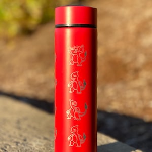 May include: A red insulated water bottle with a black lid. The bottle features a repeating pattern of a silver cartoon character. The bottle is cylindrical and appears to be made of metal.