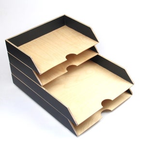 Könnte beinhalten: Drei cremefarbene Keramikbecher mit gesprenkelter Glasur. Jeder Becher zeigt ein handgemaltes Blumenmuster in Blau-, Grün- und Gelbtönen. Die Becher haben eine einfache, abgerundete Form und einen Griff.