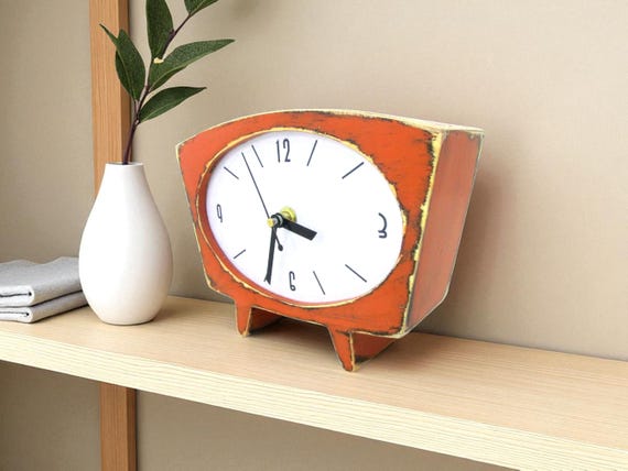A silent-mechanism orange wooden desk clock with 1,745 favorites — the standout hit of this batch, proof that people genuinely want this handcrafted MCM accent on their desk.