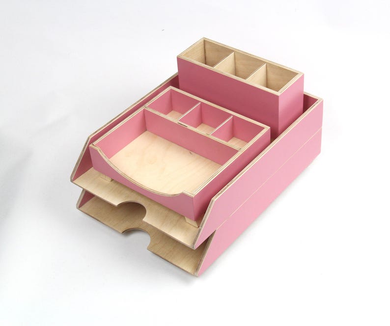 Op de afbeelding: Een roze houten bureau-organizer met meerdere compartimenten en laden. De organizer bevat een pennenhouder, een lade met verdelers en een papieren lade met twee niveaus. De binnenkant van de compartimenten is van natuurlijk hout.