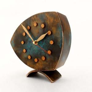 Brown wooden standing  clock with gold turquoise accents, The clock face features gold dots on round and two gold hands for hours and minutes  face