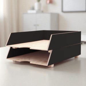 Może przedstawiać: Dwupoziomowy organizer biurowy w kolorze czarnym i naturalnego drewna. Organizer ma nowoczesny design z czarnym wykończeniem zewnętrznym i naturalnym drewnem wewnątrz. Przeznaczony na papiery i dokumenty.