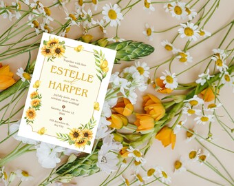 Puede incluir: Una invitación de boda con los nombres "Estelle y Harper" en letras doradas, rodeada de girasoles y vegetación en acuarela. La invitación se encuentra sobre un fondo de margaritas, tulipanes amarillos y otras flores.