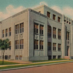 Puede incluir: Una postal vintage que representa un gran edificio de ladrillo de color claro con múltiples ventanas. El edificio tiene un techo plano y un diseño simple. La postal está descolorida y tiene un cielo azul claro en el fondo.