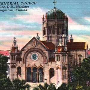 May include: A vintage postcard showing the Flagler Memorial Church in Saint Augustine, Florida. The church is a large, stone building with a tall, pointed spire and a green dome. The postcard is in colour and depicts the church in a sunny setting.