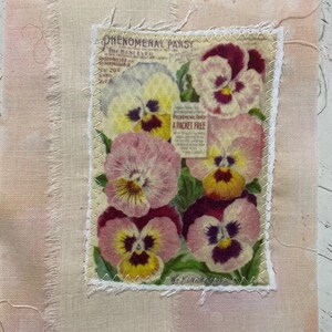 May include: A rectangular fabric patch featuring a vintage-style botanical print of pansies in shades of pink, yellow, and purple. The central panel has a zigzag stitched border and includes the text Phenomenal Pansy and A Packet Free.