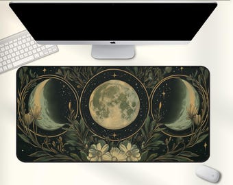 May include: A rectangular desk mat featuring a celestial design with three moon phases, stars, and floral elements in shades of green, gold, and cream. The mat is placed under a computer monitor, keyboard, and mouse.
