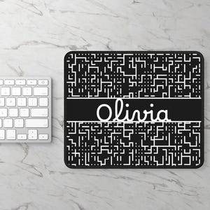 May include: Black rectangular mousepad with a white keyboard in the background. The mousepad has a white and black geometric pattern with the name "Olivia" in white script across the center.