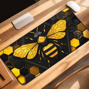 May include: A rectangular desk mat featuring a large, geometric-style bee in shades of yellow and black. The background consists of a repeating hexagonal honeycomb pattern in black, gold, and yellow, with some hexagons displaying a marble texture.