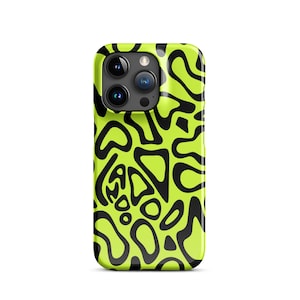 Puede incluir: Una funda de teléfono verde neón con un patrón abstracto negro. La funda tiene un acabado brillante y presenta una serie de formas irregulares, parecidas a amebas, en negro sobre el fondo verde brillante. Las lentes de la cámara del teléfono son visibles en la parte superior.