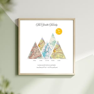 May include: A framed print featuring a family name and mountain-shaped map illustrations. The artwork includes a yellow sun, birds, and the text "I sustain myself with love and family."