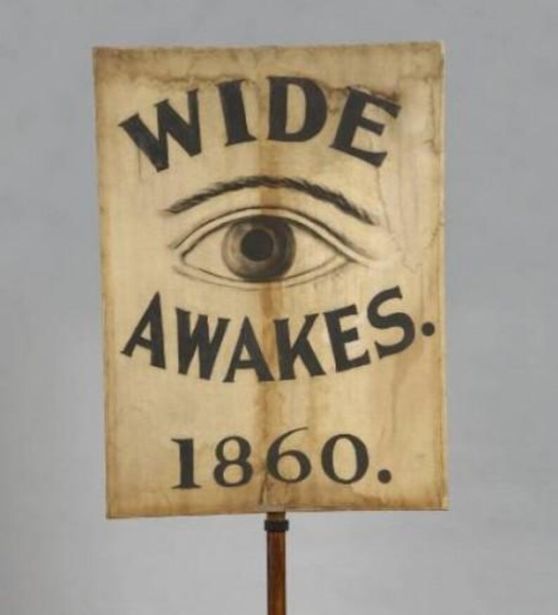 a sign with the text "WIDE AWAKES 1860" and an eye illustration.