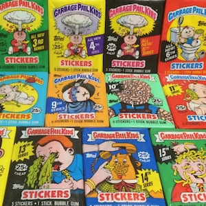 May include: A collection of vintage Garbage Pail Kids sticker packs. The packs feature colorful illustrations of grotesque characters and the text "STICKERS" and "BUBBLE GUM". The series numbers are visible on the packs.