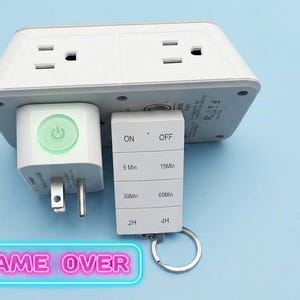 May include: A white electrical outlet adapter with two grounded sockets and a remote control featuring buttons labeled ON, OFF, 5 Min, 15 Min, 30 Min, 60 Min, 2H, and 4H. The remote has a metal key ring attached and the adapter has a green power button.