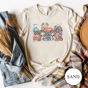 May include: A white ceramic mug with a black handle and the text "But First, Coffee" in a bold, black font. The mug is likely 11 ounces in size and sits on a white surface.