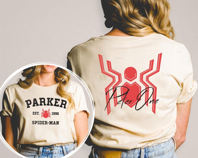 May include: Cream-colored t-shirt featuring a red and black Spider-Man design. The front of the shirt displays "PARKER EST. 1996 SPIDER-MAN" in black lettering. The back has a red spider emblem with "Peter One" in black script.