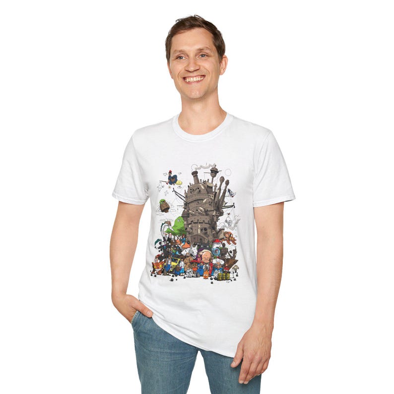 May include: White t-shirt featuring a detailed illustration of a fantastical castle with numerous characters. The artwork includes a variety of creatures and figures in a colorful, whimsical style. The shirt is made of a soft material.
